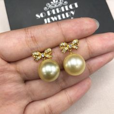 We are presenting you A PERFECT PAIR OF CREAMY WHITE SOUTH SEA PEARLS! WITH EXCELLENT LUSTER. Accented with 22 pieces or superb quality, F/VS sparkling diamonds. SET IN HANDCRAFTED, 18K SOLID YELLOW GOLD SCREWED BACK EARRINGS. DANGLING BOW DESIGN, ELEGANT AND CUTE! IN CASE OF RETURN FOR US BUYERS. BUYERS MAY SEND THE ITEMS BACK TO OUR US-BASED OFFICE IN SALT LAKE CITY, UTAH ONLY ONE ITEM AVAILABLE!! NO DUPLICATES!! WHAT YOU SEE IN THE PICTURES IS WHAT YOU WILL GET SOLIDLY HANDCRAFTED EARRINGS! S Pearl Bridal Earrings In Yellow Gold As Gift, Yellow Gold Pearl Bridal Earrings Gift, Luxury Gold Round Bridal Earrings, Elegant Yellow Bridal Earrings For Wedding, Luxury Round Pearl Earrings For Wedding, Gold Pearl Round Bridal Earrings, Luxury Pearl Bridal Earrings Gift, Exquisite Gold Pearl Earrings For Anniversary, High Luster Yellow Jewelry For Weddings