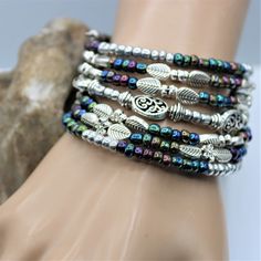 Fun and festive this seven layer bracelet is sure to make a fresh statement. The layered silver and colored beads give that fun boho vibe which will compliment nearly all outfits, and is perfect for everyday, beach vacations, or special occasions. #memorywirebracelet #handmade #statementjewelry #crystals #beads #bracelet #coilbracelet #jewelerydesign #jewelrydesigner #statementbracelet #jewelery #oneofakindjewelry #dramatic #handcraftedbracelets #fashion #love #pearls #style #wedding Bohemian Multi-strand Beaded Bracelets With Silver Beads, Bohemian Hand Wrapped Metal Beaded Bracelets, Multicolor Bohemian Beaded Bracelets With Silver Beads, Bohemian Metal Beaded Stackable Bracelets, Stackable Bohemian Metal Beaded Bracelets, Bohemian Silver Beaded Bracelets With Spacer Beads, Bohemian Silver Beaded Bracelets Hand Wrapped, Bohemian Multi-strand Silver Beaded Bracelets, Bohemian Multicolor Bracelets With Silver Beads