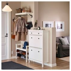 a white cabinet sitting next to a couch in a living room