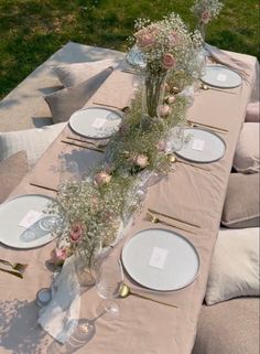 the table is set with flowers and plates