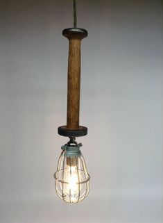 an old fashioned light bulb hanging from a wooden pole with a wire wrapped around it