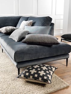 a living room with a couch and pillows on the floor