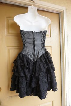 "Vintage size small black dress with leather sweetheart bodice and ruffle lace layered skirt. Zips up the back. In good vintage condition but the puller on the zipper need to be reconnected somehow - see last photo. Measurements taken across front laid flat 16\" across front armpit to armpit 12.5\" across front of waist -doubles to 25\" 19\" across front of hips 26\" length armpit to bottom" Fitted Steampunk Corset Dress For Evening, Steampunk Corset Dress For Party With Fitted Bodice, Black Steampunk Corset Dress For Party, Steampunk Corset Dress For Parties, Black Overbust Corset Dress For Formal Occasions, Black Corset Dress With Lace Trim For Formal Occasions, Steampunk Fitted Corset Dress For Evening, Black Corset Dress For Alternative Fashion, Vintage Fitted Corset Dress For Alternative Fashion