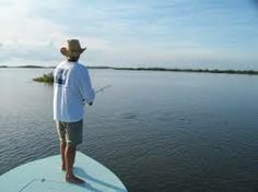 a man standing on top of a surfboard in the middle of a body of water