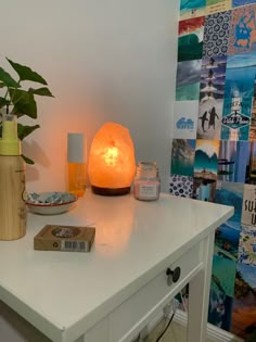 a white table topped with a lamp next to a plant