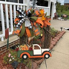 an orange and black truck with a bow on it sitting in front of a house