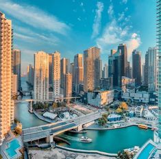 an aerial view of a city with tall buildings and boats in the water near it