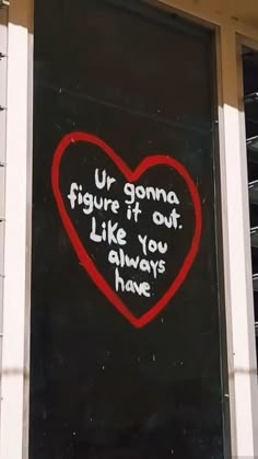 a heart painted on the side of a building with words written in white and red