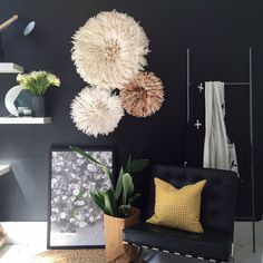 a living room filled with furniture and art on the wall next to a plant in a vase