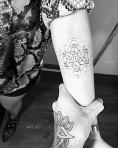 two people holding hands with tattoos on them