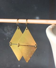 Simple, geometric, and bold.  These earrings feature simple brass triangles, linked together to form a cool golden diamond.  Perfect to elevate every outfit.  Earrings measures about 2.25" long.  These earrings are so fashion-forward, and so beautiful, too.  Earrings measure 2.25" long. Geometric Metal Earrings For Everyday, Adjustable Geometric Minimalist Earrings, Adjustable Minimalist Geometric Earrings, Gold Triangle Minimalist Earrings, Minimalist Gold Triangle Earrings, Triangle Gold Metal Earrings, Gold Triangle Metal Earrings, Adjustable Gold Triangle Earrings, Gold Triangle Jewelry With Ear Wire