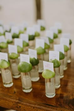 small glasses filled with green fruit on top of a wooden table