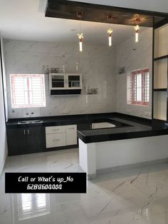 an empty kitchen with marble counter tops and white cabinets, along with black accents on the walls