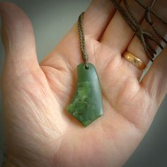 FLOATING A medium sized New Zealand Pounamu drop pendant by Ric Moor. The jade is a beautiful, semi-translucent green with beautiful mineral inclusions - a wonderful soft stone. This is a piece to hold to the light and wear daily with joy. 'FLOATING', a hand-carved piece of art that brings a little unique elegance to your wardrobe. The best view is the very brief video we have made of the pendant slowly rotating. You will see the shape and the colour of the jade very clearly. The finish is a buffed sheen. FLOATING is lovingly packaged in a woven kete pouch for you. Delivery with Express Courier is included in the price. Meaning: Healing ~ Positive Energy ~ Comfort Artist: Ric Moor Material: New Zealand Pounamu, Jade Cord Colour: Khaki 4-Plait Cord Length: Adjustable Finish: Matte Size: 46m Matte Size, Necklace Art, Best View, Jade Jewelry, Small Pendant, Drop Pendant, Drop Necklace, Unique Colors, Positive Energy