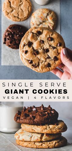 a person holding up a giant chocolate chip cookie in front of other cookies and milk