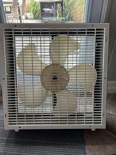 an air conditioner sitting on top of a carpeted floor next to a window