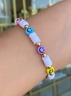 a woman's arm wearing a bracelet with smiley face beads and smiling faces on it