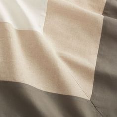 a close up view of a bed sheet with white and brown stripes on it's edges