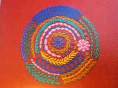 a colorful crochet design on an orange surface