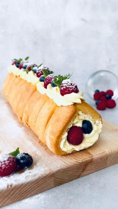 a long pastry with berries and cream on it