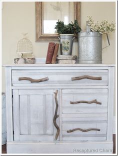 a white dresser with books and vases on top