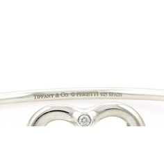 Material: sterling silver Hallmark: Tiffany & Co. Peretti 925 Spain Measurement: inner circumference: 6.5" x 0.10" thick Heart: 0.77" tall x 0.84" wide x 0.16" thick Weight: 13.4 grams  This authentic bangle is from Tiffany & Co. by designer Elsa Peretti from her Open Heart collection. It is crafted from sterling silver with a 2.5mm thick wire bangle, the front has the contour open heart with a 2 points diamond at the top of the heart. One end of the bangle has a small curved hook which and secu Luxury Sterling Silver Heart Bracelet For Gift, White Gold Bangle With Sterling Silver Clasp For Anniversary, Luxury Silver Bracelets For Valentine's Day, Luxury Sterling Silver Heart Bracelet For Anniversary, Fine Jewelry Silver Heart Diamond Bracelet, Luxury Sterling Silver Bracelets For Valentine's Day, Silver Bracelets For Valentine's Day Formal Occasion, Silver Bracelets For Valentine's Day Formal Event, Valentine's Day Silver Bracelet For Formal Occasions