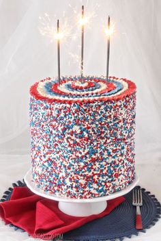 a red, white and blue cake with sparklers on top is shown in an instagram