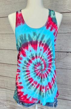 This is a tie-dye tank top.  JUNIORS FIT ( runs small for womens)  Size XL 100% cotton  See photos for size chart Spring Acid Wash Cotton Tank Top, Spring Tie Dye Tank Top, Acid Wash Cotton Tank Top For Festivals, Festival Acid Wash Cotton Tank Top, Blue Casual Tank Top For Festival, Casual Blue Tank Top For Festivals, Casual Red Festival Tank Top, Tie Dye Cotton Tank Top, Cotton Tie Dye Tank Top For Festivals