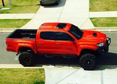 an orange truck parked on the side of a road