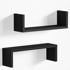 two black shelves on the wall, one is empty and the other has no shelf