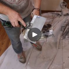 a man is sanding the floor in his house with a pair of scissors and tape