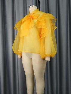 Step into sophistication with our Yellow Tulle Blouse, a captivating blend of elegance and contemporary style. This exquisite piece is designed for the modern woman who seeks to make a statement in every setting. The sheer tulle fabric adds a touch of allure, while the charming bowtie and delicate ruffles trim elevate the blouse to a new level of chic.Perfect for office wear, the blouse seamlessly transitions from professional to party-ready. Its versatile design ensures you stand out in both fo Tulle Tops, Tulle Blouse, Ruffle Trim Top, Tulle Top, Fishnet Top, Patchwork Top, Single Line, Elegant Shirt, Feminine Look