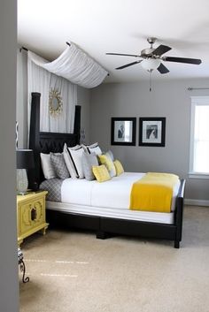 a bed room with a neatly made bed and a ceiling fan