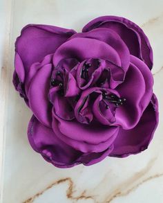 a purple flower sitting on top of a white counter