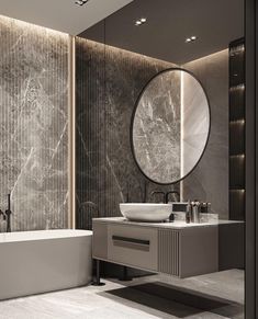 a bathroom with marble walls and flooring next to a bathtub in front of a round mirror