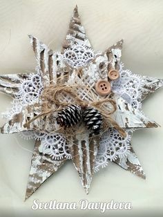 an ornament made out of lace and pine cones