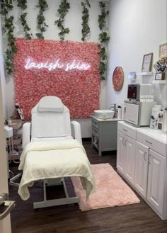 a room with white furniture and pink flowers on the wall, along with a neon sign that says love is in bloom