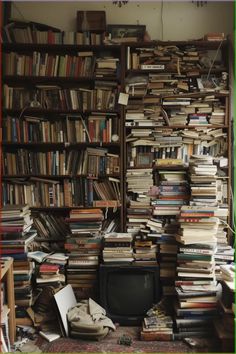 a room filled with lots of books next to a tv