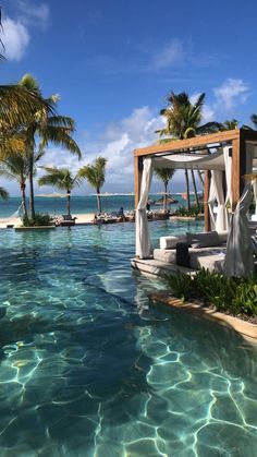 an outdoor swimming pool surrounded by palm trees