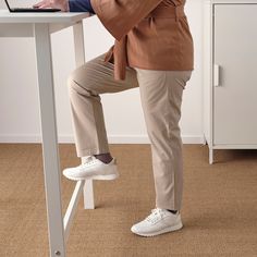 a person sitting at a desk with their feet on the table and using a laptop