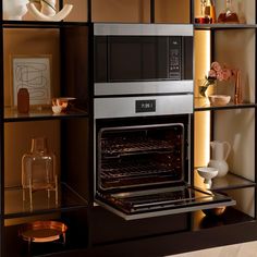 an oven built into the side of a bookcase with glass shelves on each side