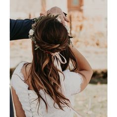 the bride is getting ready to walk down the aisle in her wedding dress and flower crown