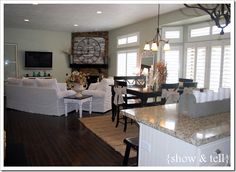 a living room filled with furniture and a flat screen tv mounted to the wall over a fireplace