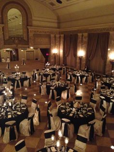 an elegant ballroom with black and white linens