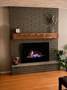 a living room with a brick fireplace and wood floors