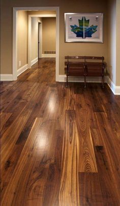 an empty hallway with wood floors and benches