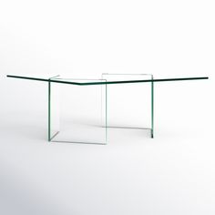 an empty glass table sitting on top of a white floor with no one around it