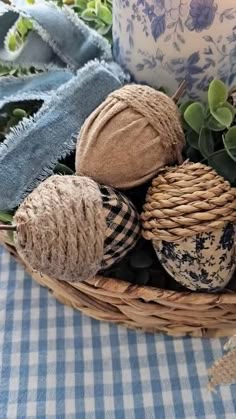 a wicker basket filled with different types of fabric and other decorative items next to a candle