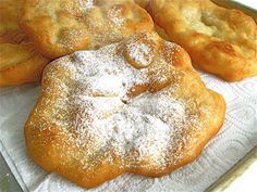 four pastries are sitting on a white towel with powdered sugar sprinkles