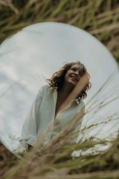 a woman standing in front of a round mirror